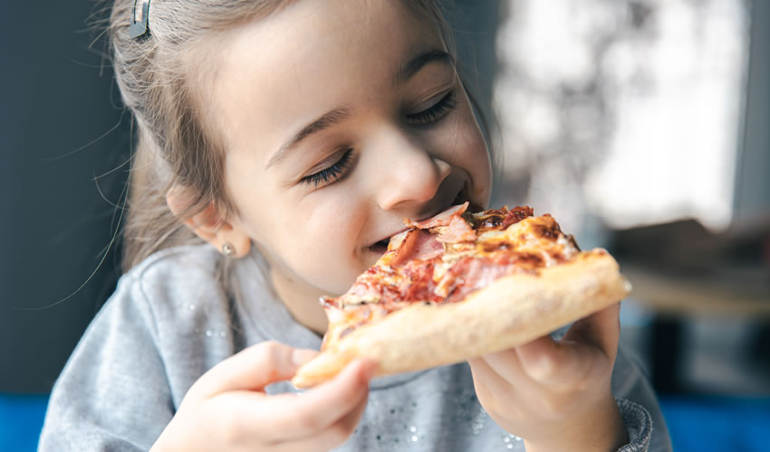 little girl with an appetizing piece of pizza