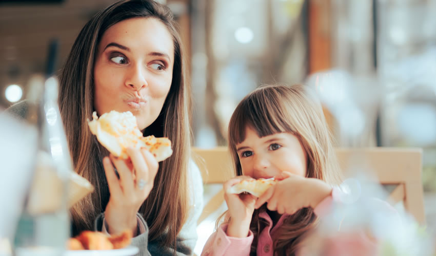 Hungry Mom and Daughter Having Pizza